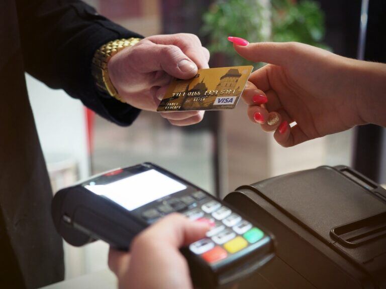 person handing over credit card at POS machine