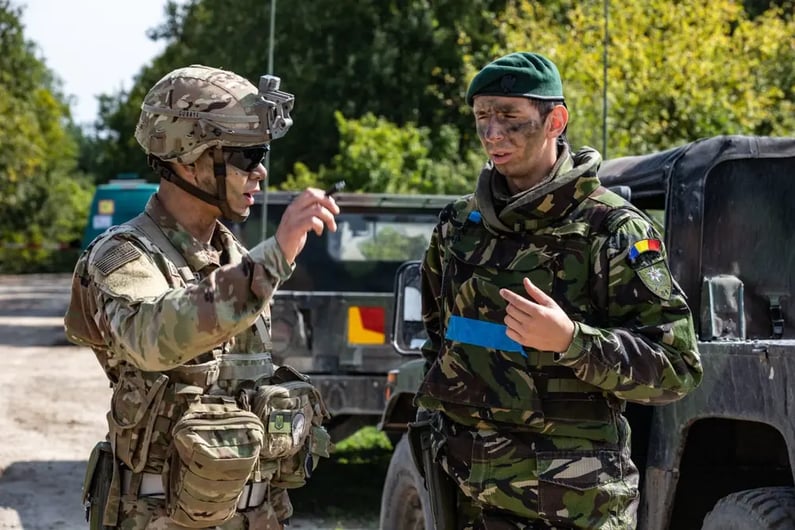 1Lt. Tim Suwandhaputra speaks with a Romanian soldier at a checkpoint during Rapid Trident 18, Yavoriv, Ukraine, Sept. 10, 2018. U.S. Army photo by Sgt. Timothy Massey, 278th Armored Cavalry Regiment, Tennessee Army National Guard. Image courtesy of DVIDSHUB.