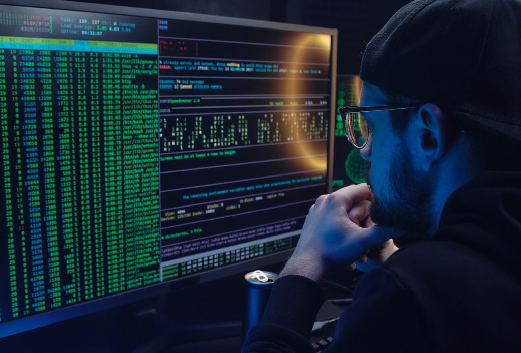 man in front of dark computer screen